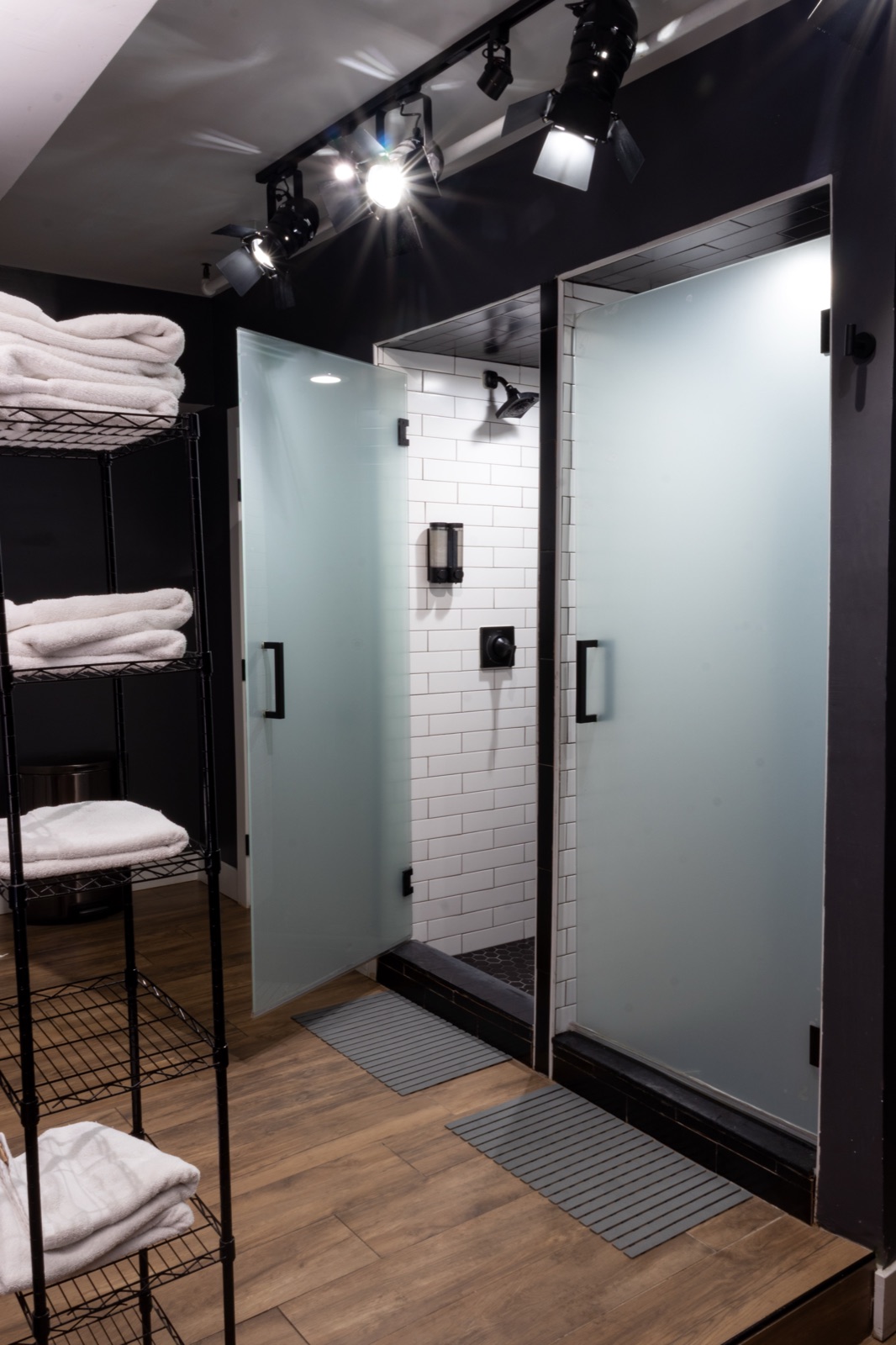 Men's showers — frosted glass stalls with towel shelves